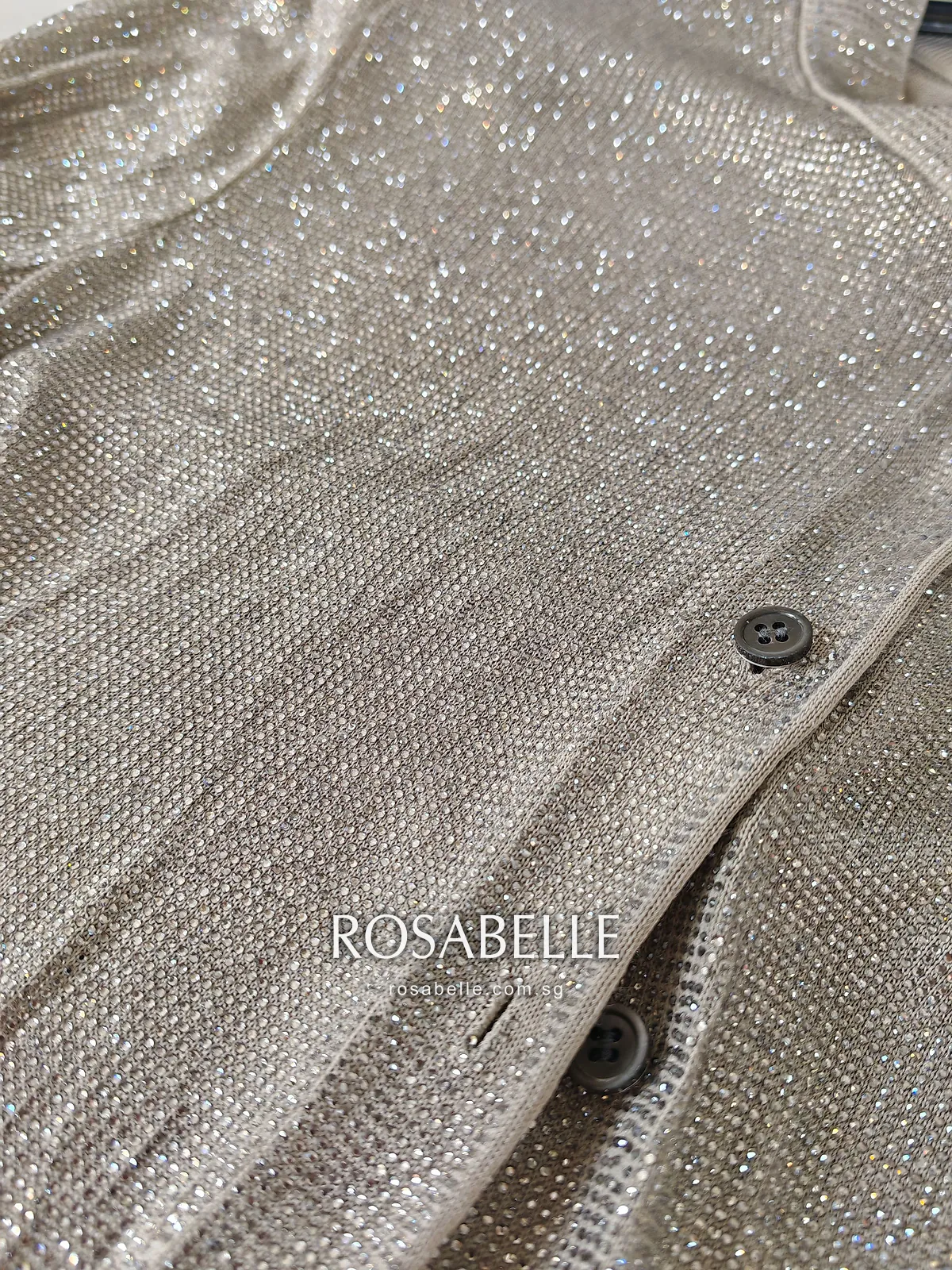 Button placket up close, dark buttons sitting between the bead-covered front panels of the cardigan