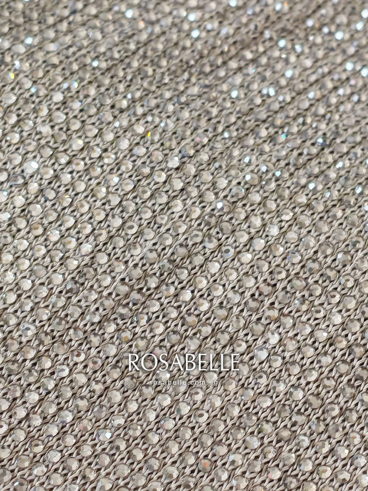 Close view of the champagne viscose knit with rows of small round clear beads fixed across its surface