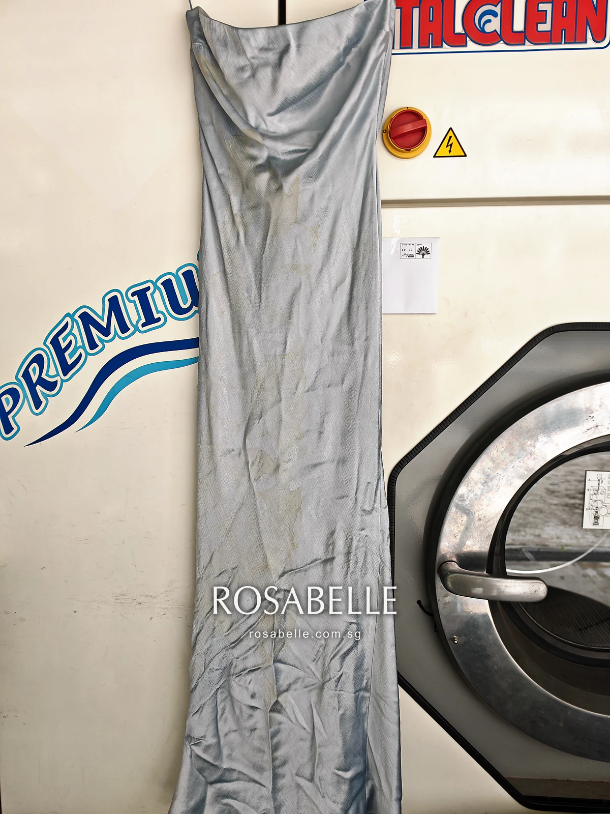 Pale blue Bec + Bridge viscose maxi dress hanging full length, brown blotches from bag dye across the front