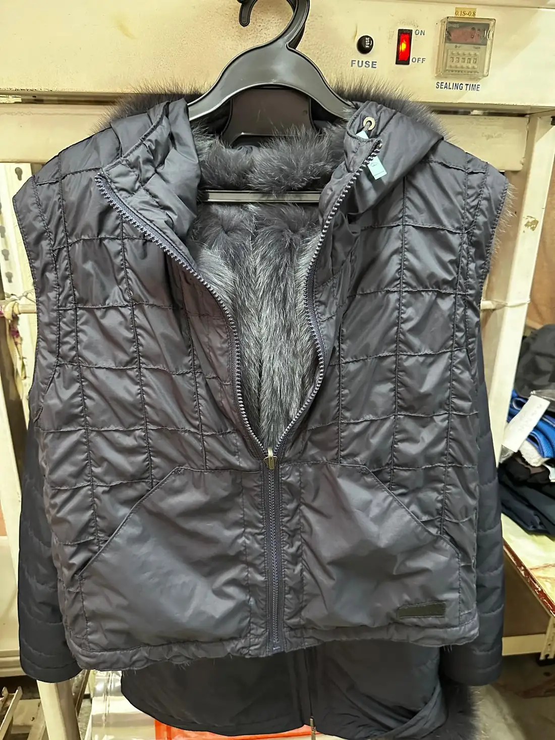 The parka's layered construction visible: quilted inner jacket over the blue fox fur lining during cleaning at Rosabelle Launderette