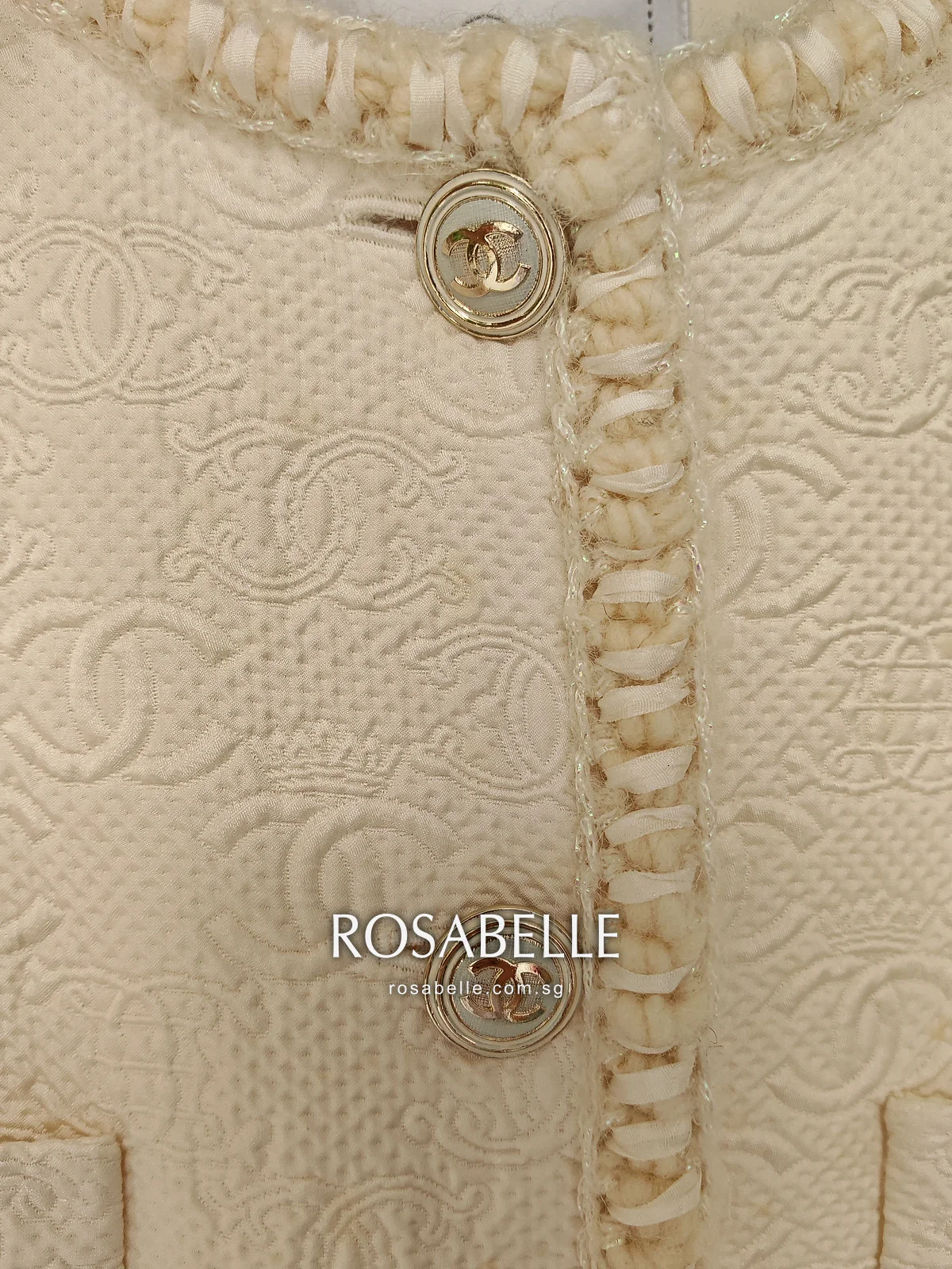 Braided front edge and gold CC buttons on the cream jacket before cleaning, spots on the cloth beside them