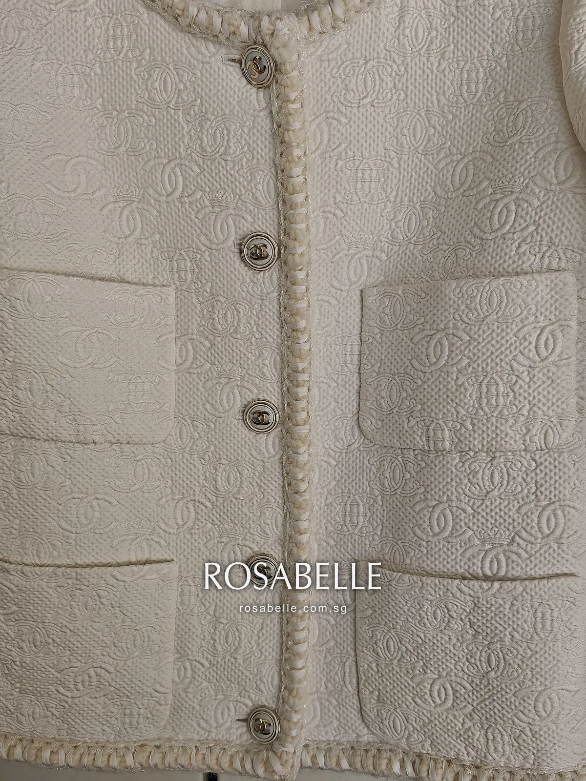 Close view of the cleaned jacket front, the raised interlocking-CC cloth clear around the patch pockets and gold buttons