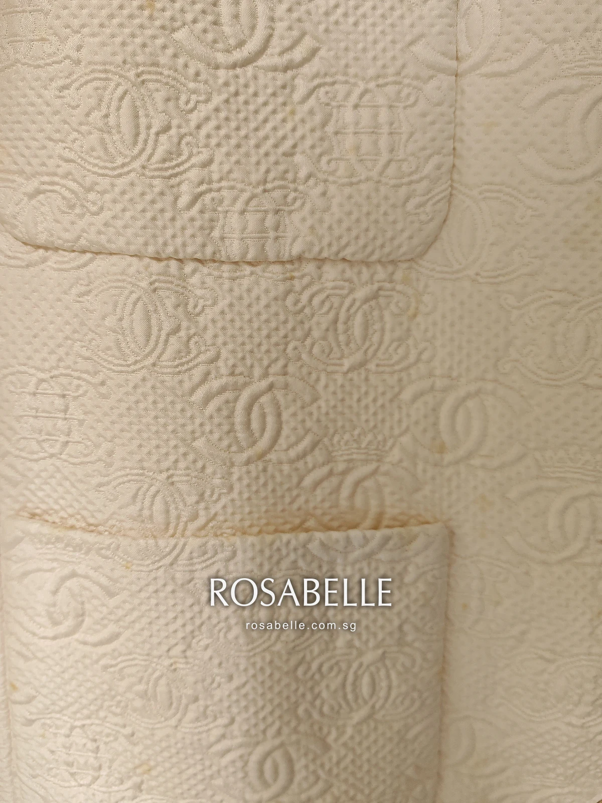 Close view of the raised interlocking-CC cloth with small yellow spots along a patch pocket edge