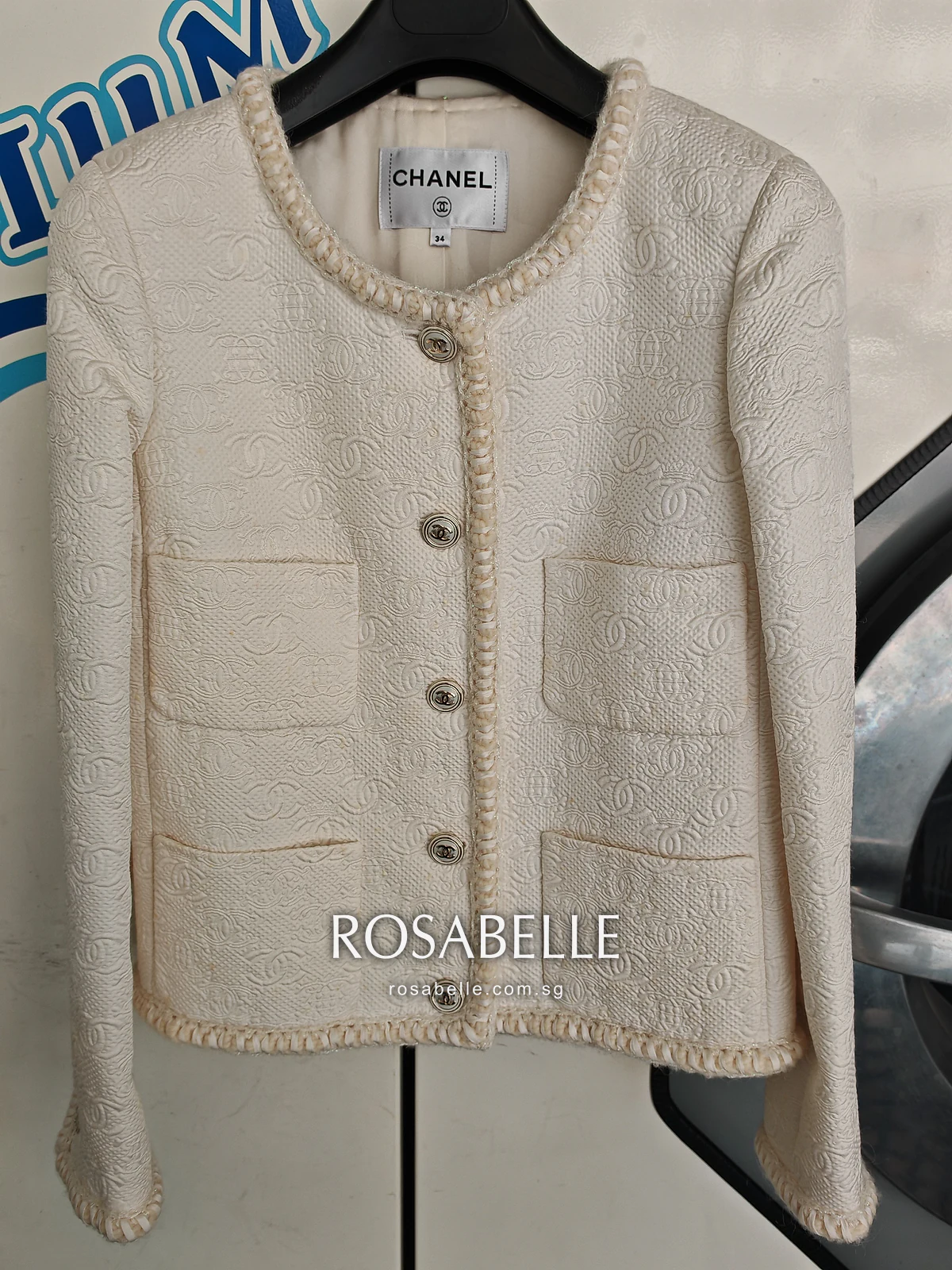 The same cream Chanel jacket after cleaning, its raised CC pattern, pockets and braided edges intact