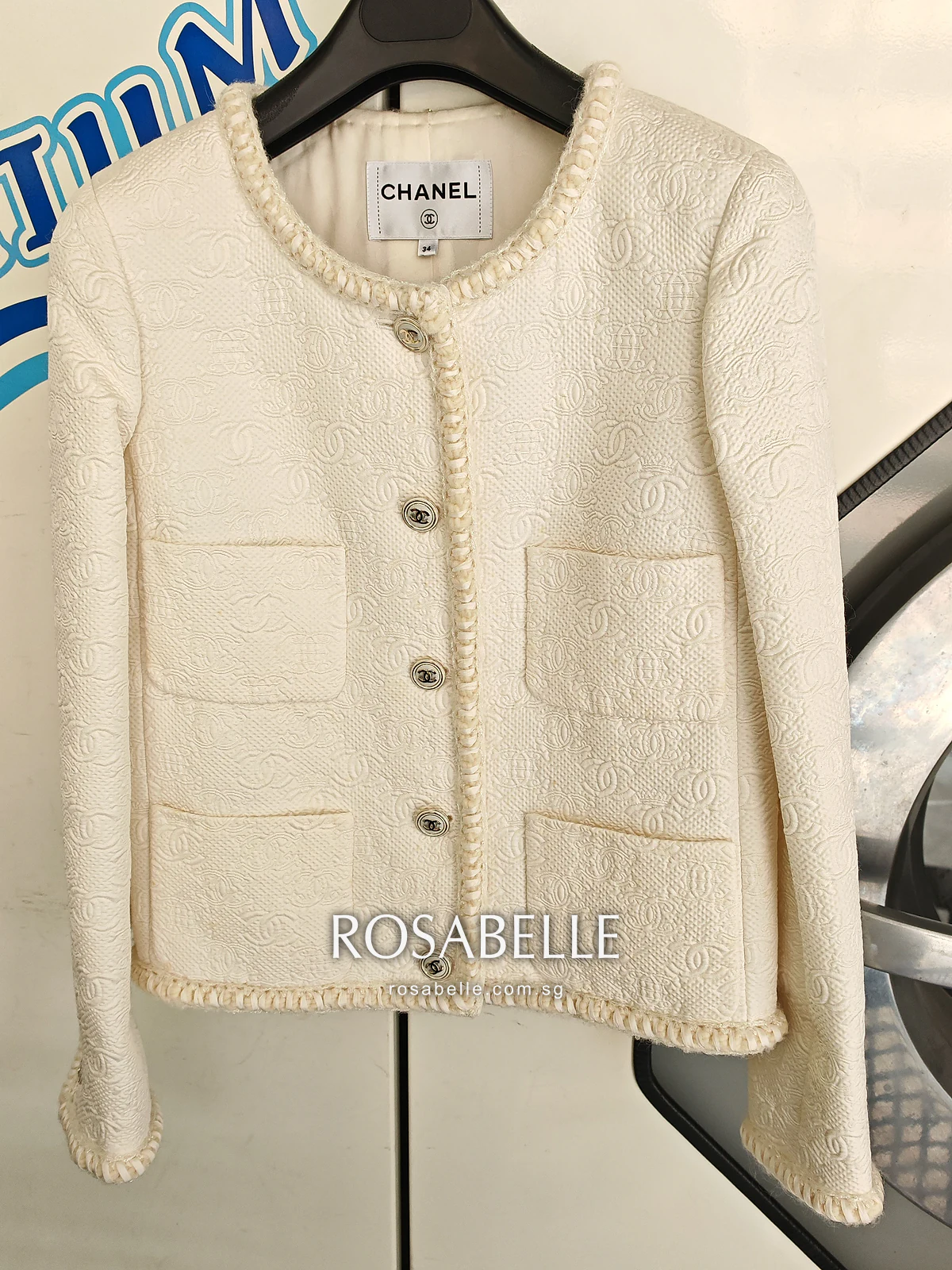 Cream Chanel wool and silk jacket on a hanger with yellow spots from storage, before cleaning