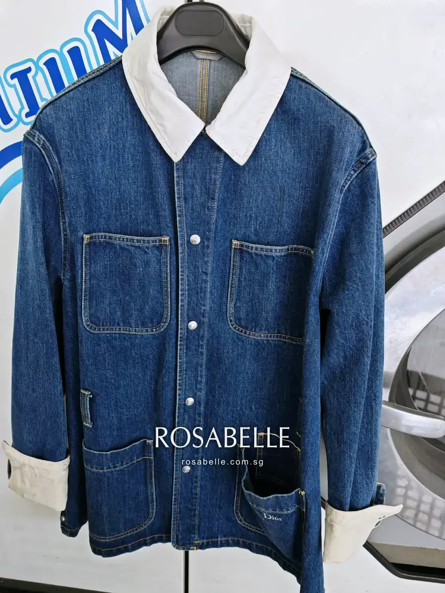 A Christian Dior indigo denim chore jacket with a yellowed cream collar and cuffs, before cleaning at Rosabelle Launderette Singapore