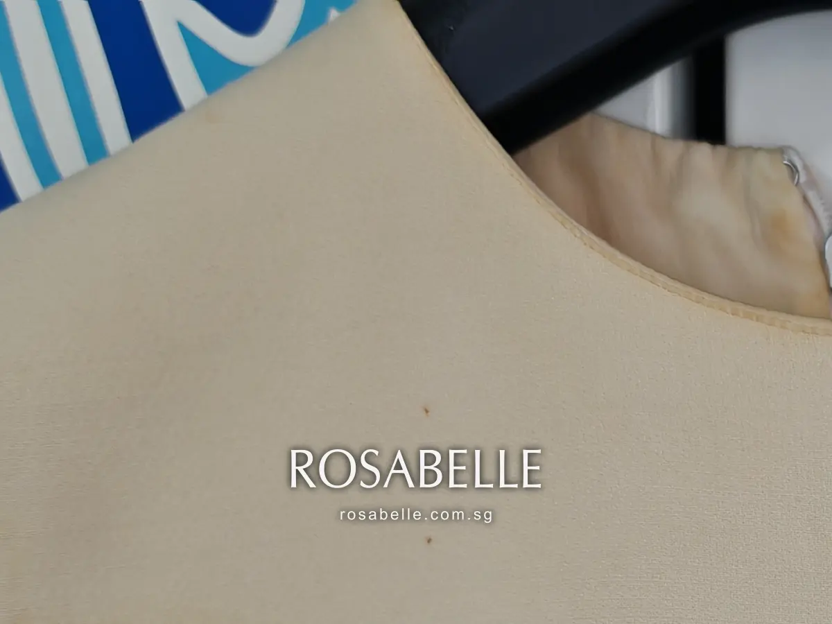 Front neckline of the cream Dior dress before cleaning, the edge soiled and small dark spots on the wool and silk