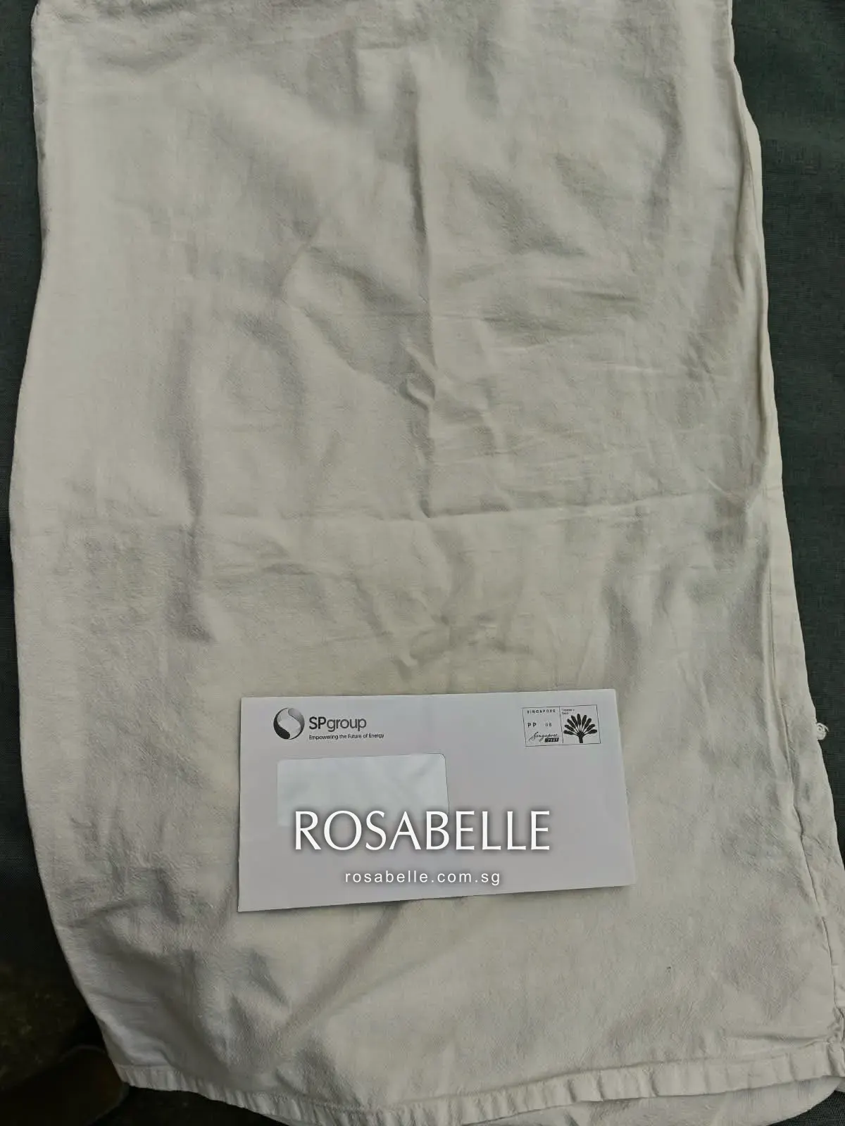 White cotton duvet cover gone yellow, a plain envelope laid on it for comparison