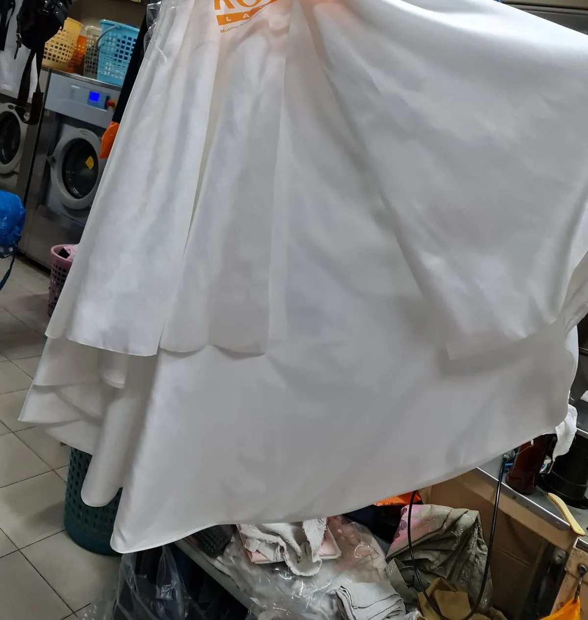 Close-up of the same gown hem clean and white after restoration by Rosabelle Launderette