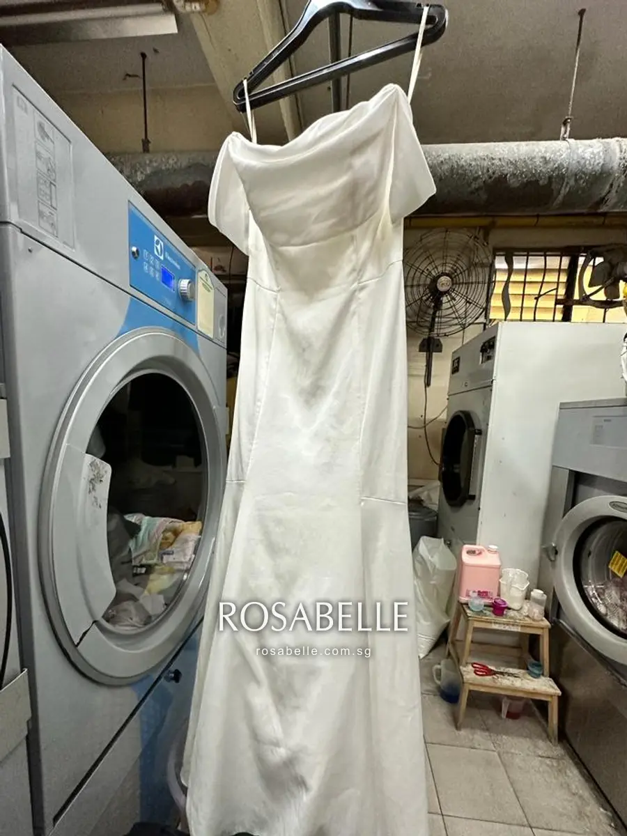 The same satin gown after cleaning, hem and train returned white