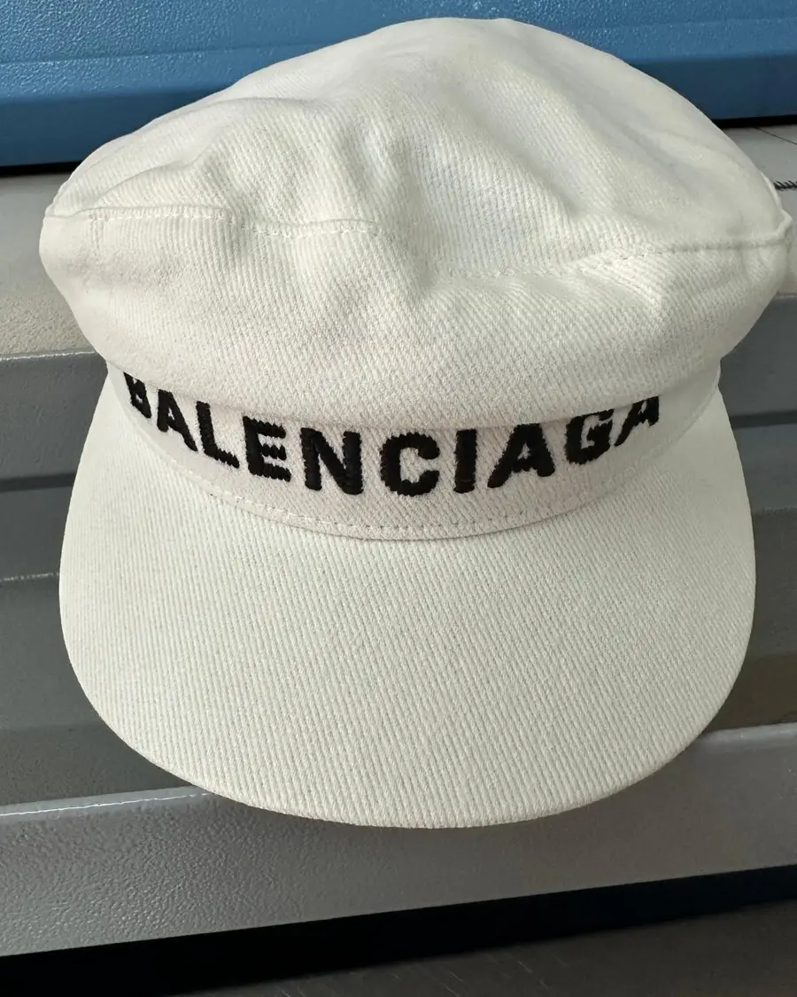 White cotton twill baker boy cap with a woven logo band, in for cleaning and blocking at Rosabelle Launderette Singapore