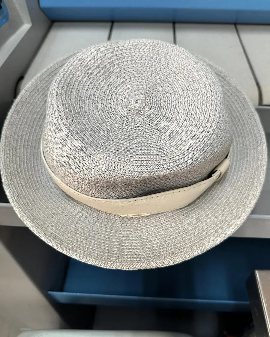 Fine straw hat with a leather band, photographed from above showing the crown where hair oil and sun cream collect