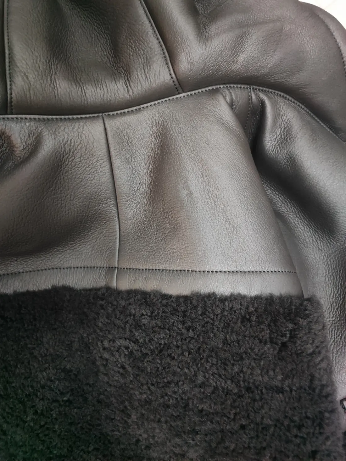Detail of the Hermès shearling where the conditioned leather face meets the wool fleece of the same skin