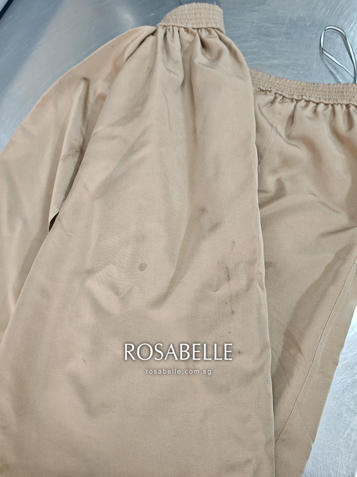 Wrap panel of the camel silk skirt folded open before cleaning, a scatter of darker food spots on the fabric