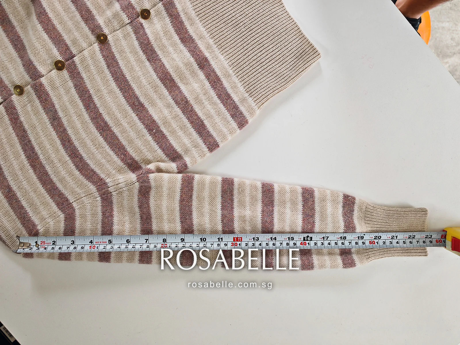 Second sleeve after reblocking, stripes running straight across it above the tape to the ribbed cuff