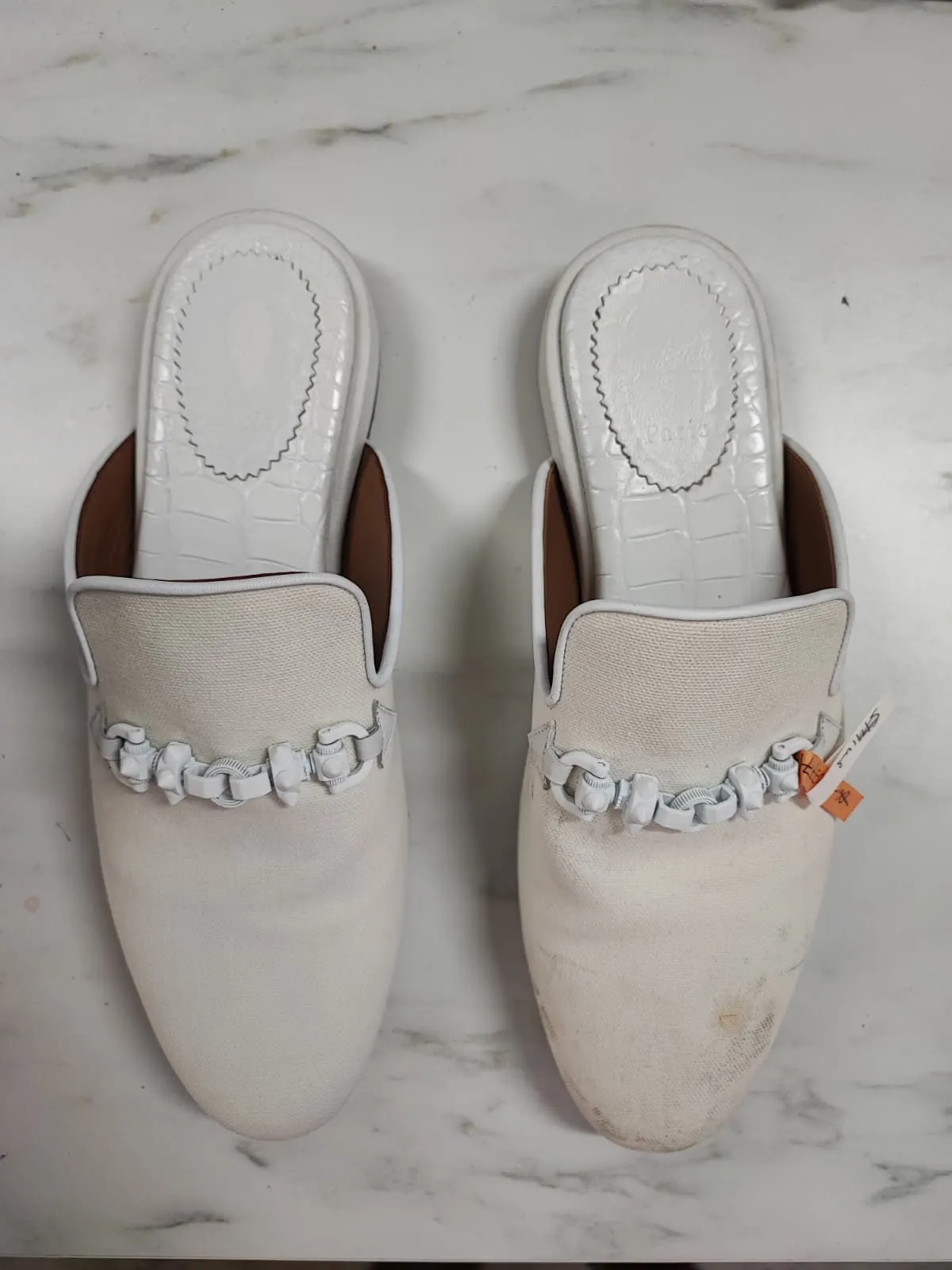 Christian Louboutin white canvas mules with toe scuffs and grey staining before cleaning — Rosabelle Launderette case study