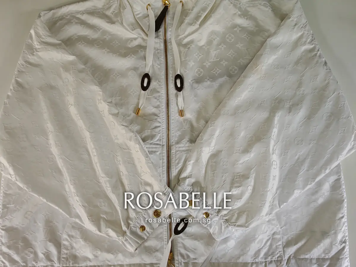 The same Louis Vuitton parka laid flat after cleaning, sleeves folded across, embossed monogram clear of any dye