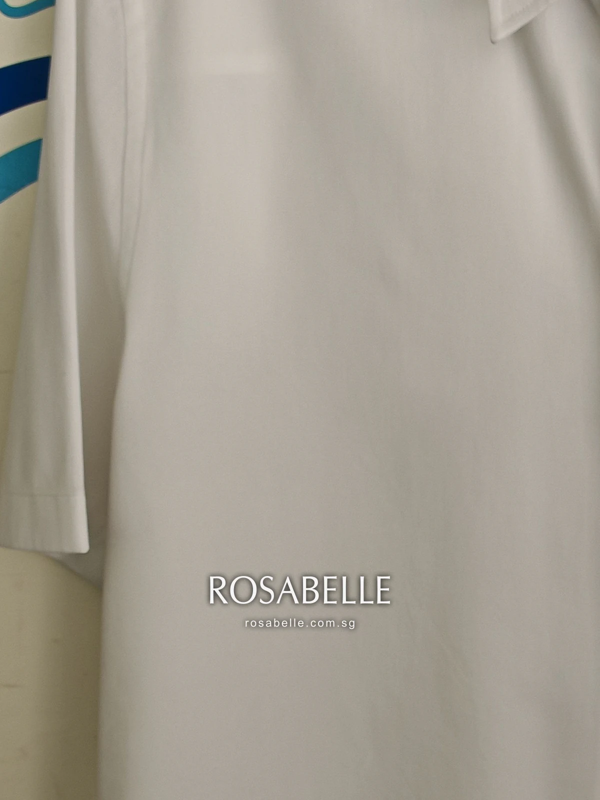 Front panel of the Louis Vuitton shirt after cleaning, plain white poplin hanging straight with no lines