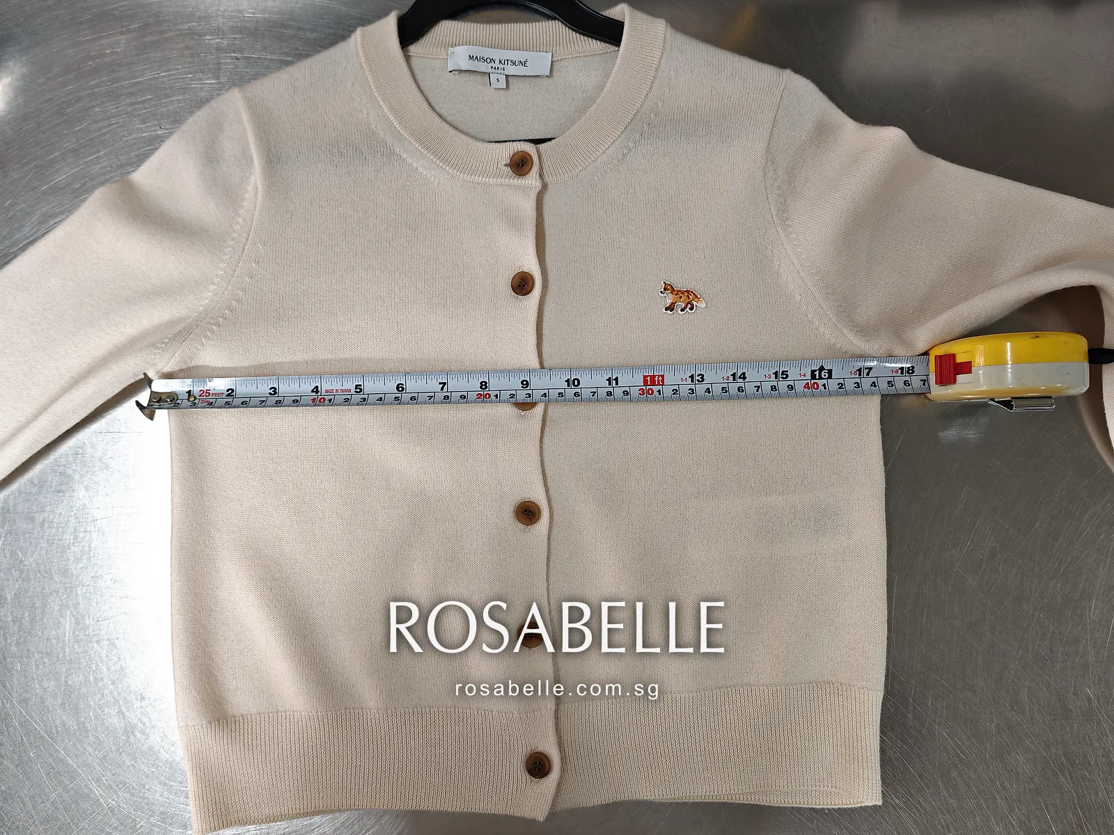 Reblocked beige cardigan with the tape across the chest at the armholes, ribbed hem lying flat below