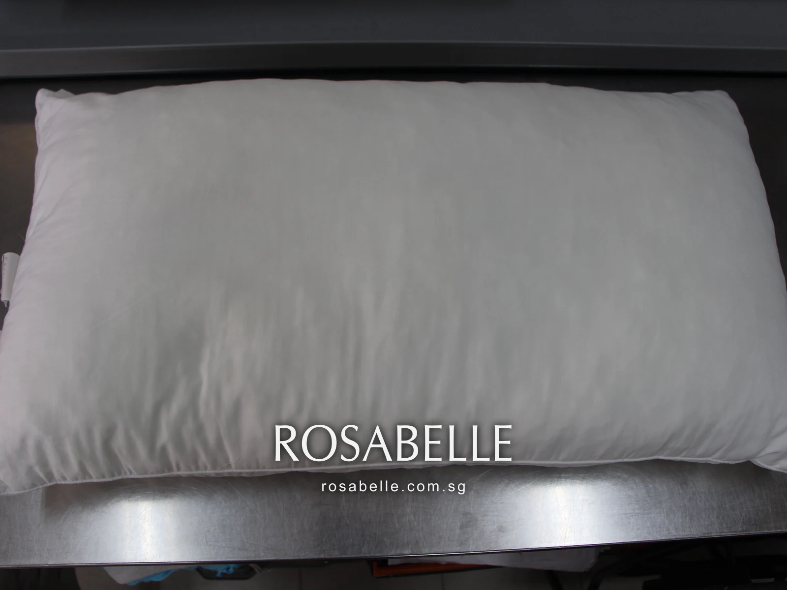Plain long pillow after cleaning, smooth and evenly white on the steel work table