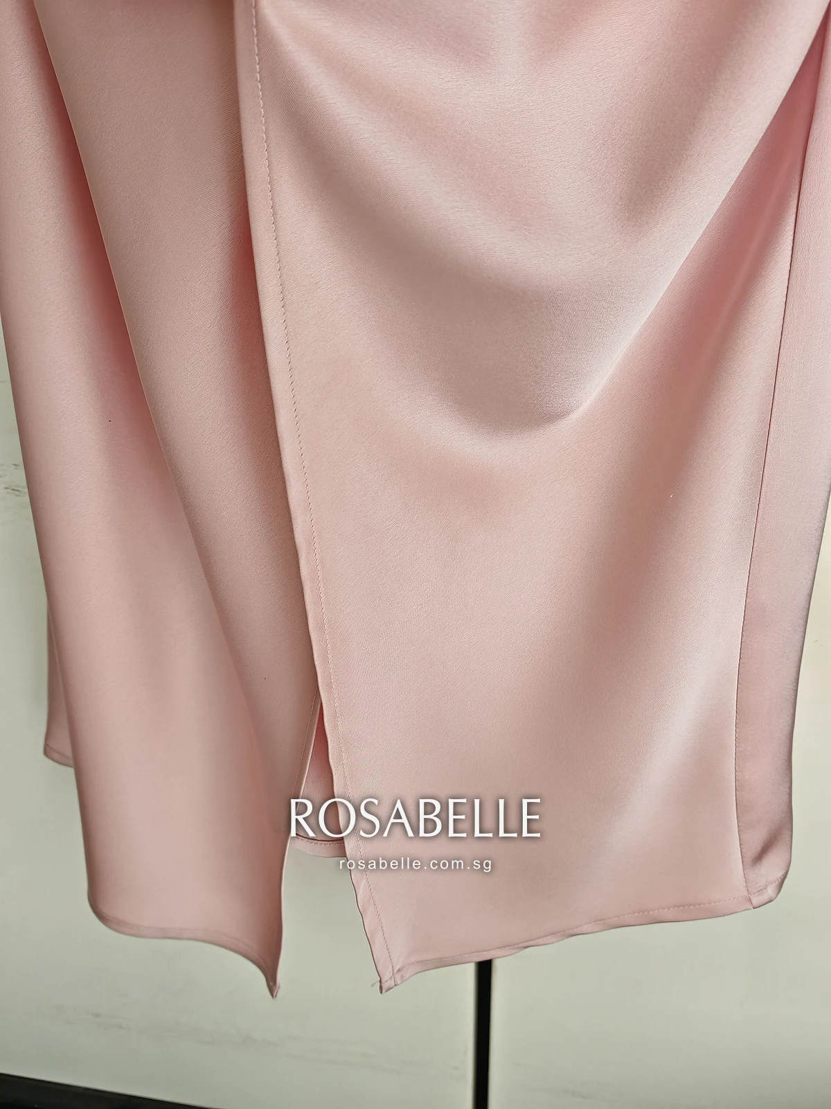 Lower skirt of the pink satin slip dress after cleaning, the side slit and hem hanging clean and even