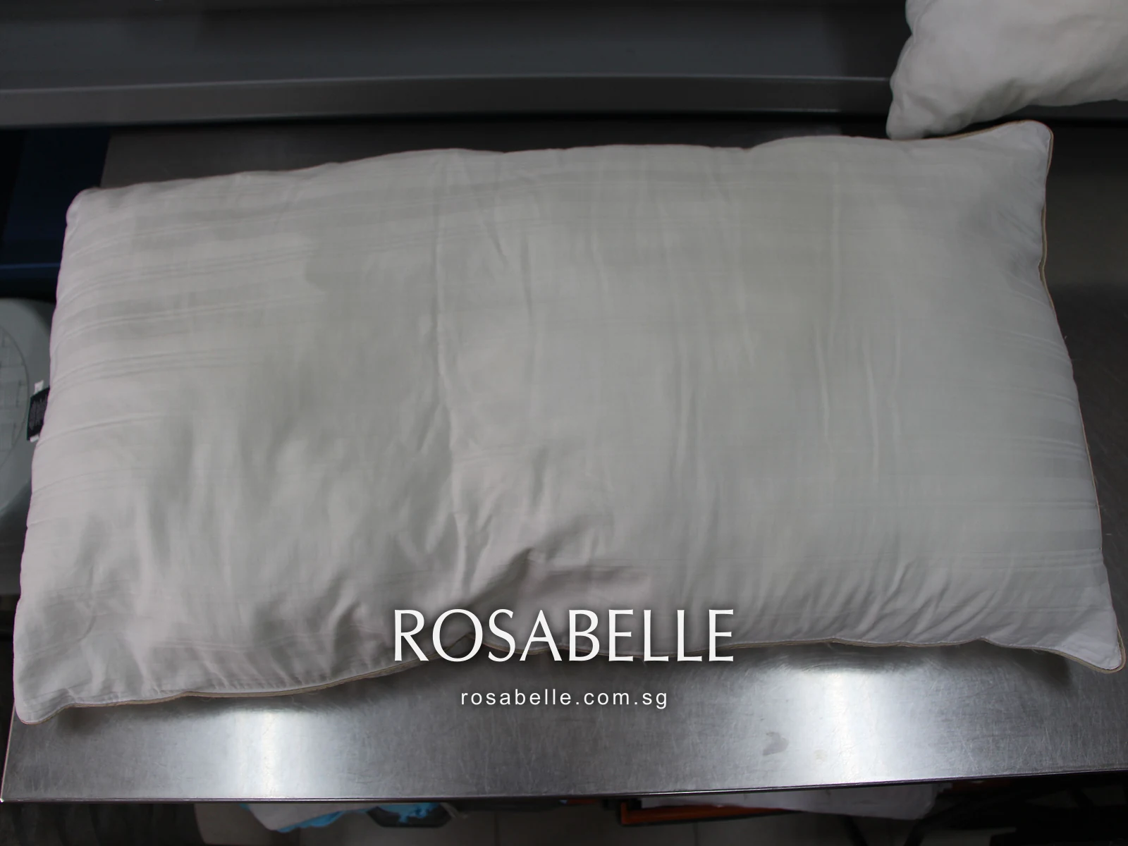 Striped pillow after cleaning, its woven stripe even and no mould lines left, on the steel table