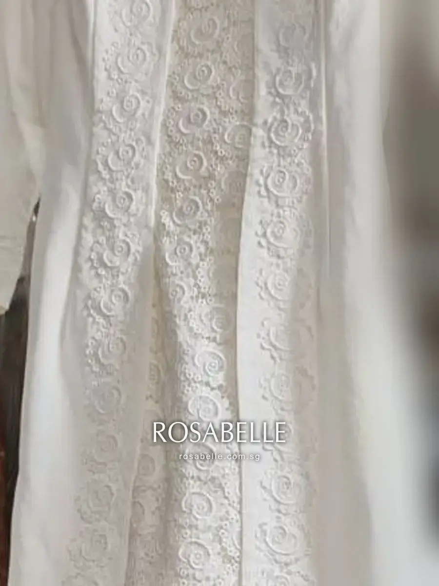The centre-front panel in detail, dense raised scrollwork worked in bands of ivory thread